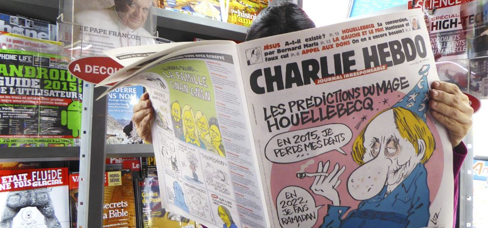 Una mujer lee el último número del semanario satírico "Charlie Hebdo" en un quiosco en París, Francia.