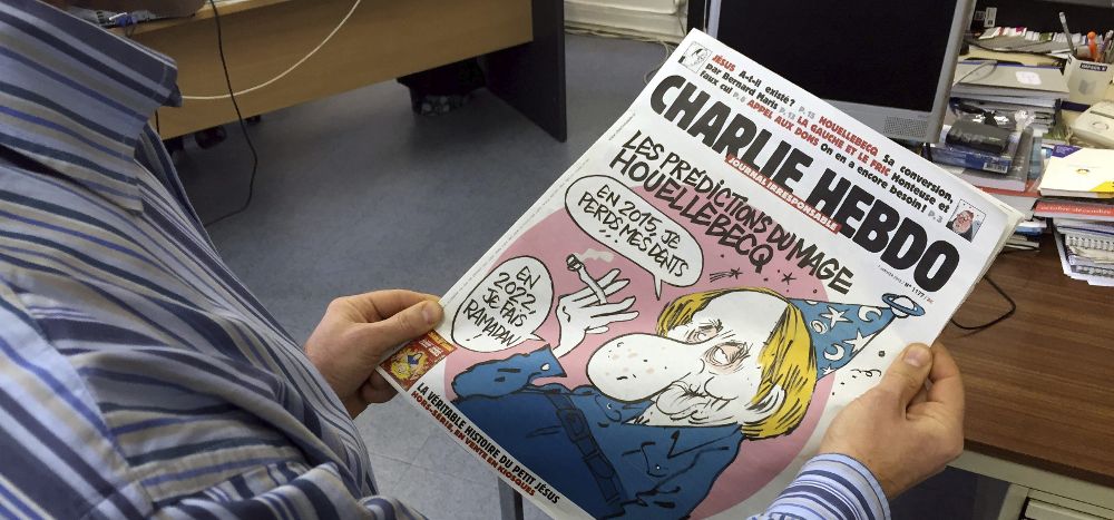 Un periodista mira la portada del último número del semanario satírico "Charlie Hebdo".