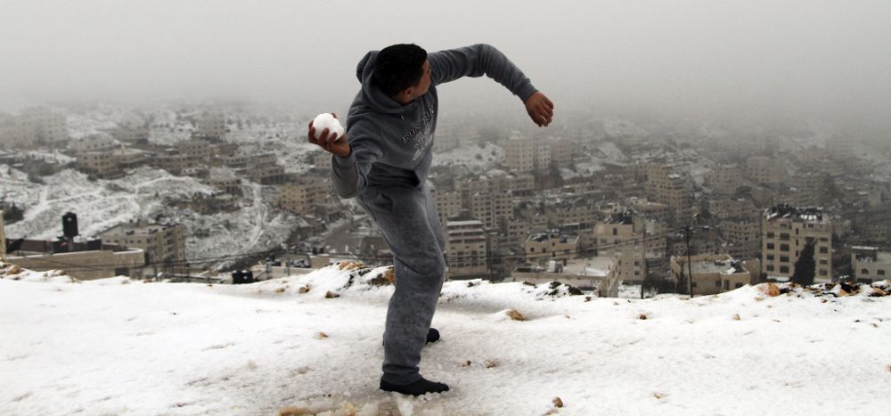 Un palestino lanza una bola de nieve en la ciudad cisjordana de Nablus.