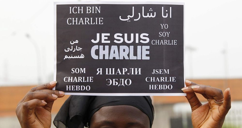 Una mujer sostiene un cartel de apoyo a la publicación Charlie Hebdo, frente a la embajada francesa en Costa de Marfil.