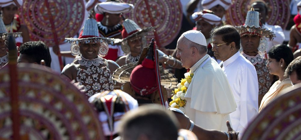 El papa Francisco (3ºdcha) y el presidente de Sri Lanka, Maithiripala Sirisena (2ºdcha) caminan entre baolarines en el aeropuerto de Colombo (Sri Lanka) hoy, martes 13 de enero de 2015.