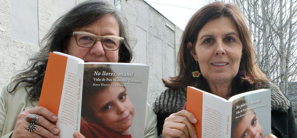 La escritora Rosa María Carbonell (d) y la editora Rosa Serra (i) posan con un ejemplar de "No llores, mami".