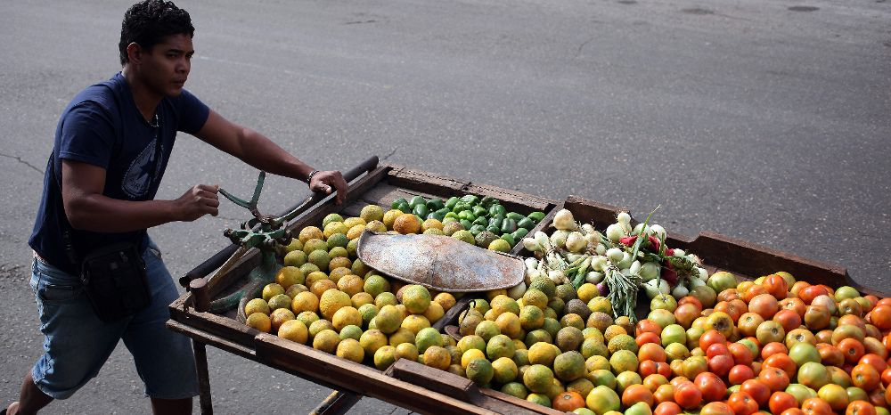 Un carretillero vende frutas y vegetales.