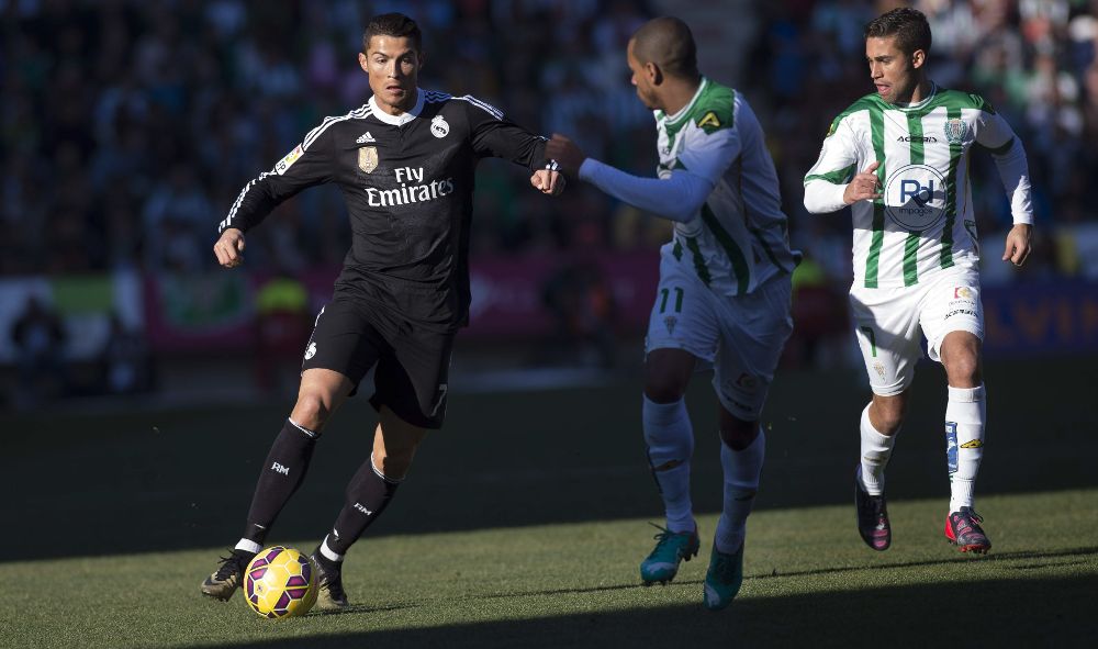 Cristiano Ronaldo (i) pelea un balón con Fraga (c).