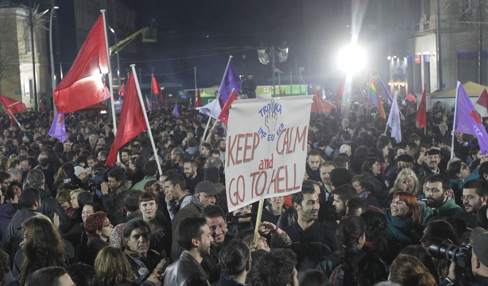 Una pancarta con el mensaje: "Troika, calma y váyanse al infierno" durante las manifestaciones de júbilo de anoche durante la alocución de Alexis Tsipras a sus seguidores.