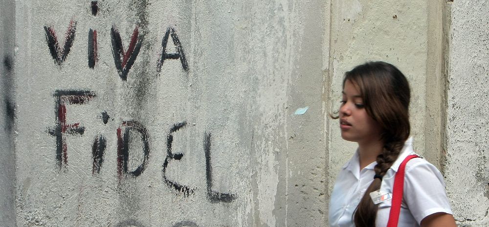 Una joven estudiante camina junto a un grafiti.