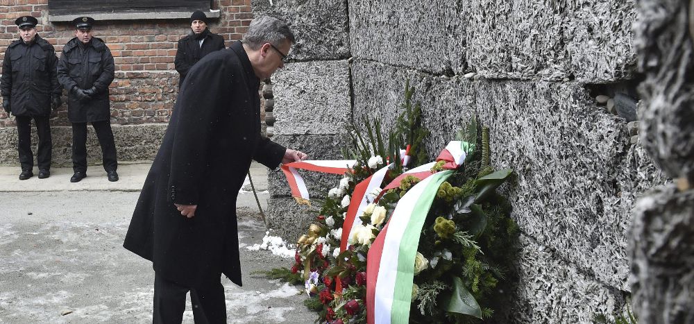 El presidente polaco, Bronislaw Komorowski (c), deposita una corona de flores ante el llamado "Muro de la Muerte".