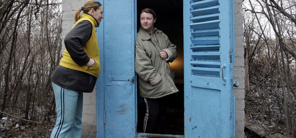 Dos mujeres conversan en la entrada de un refugio antibombas en Donetsk, Ucrania.