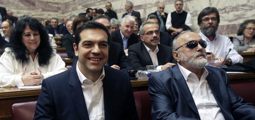 El primer ministro griego y líder del partido izquierdista Syriza, Alexis Tsipras (i), junto al ministro griego de Sanidad y Asuntos Sociales durante una reunión de su grupo parlamentario en el Parlamento en Atenas, hoy, jueves.