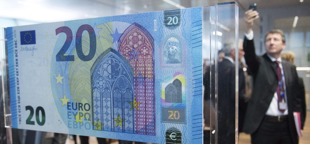 Un hombre fotografía el nuevo billete de 20 euros en el Banco Central Europeo (BCE), en Fráncfort (Alemania).