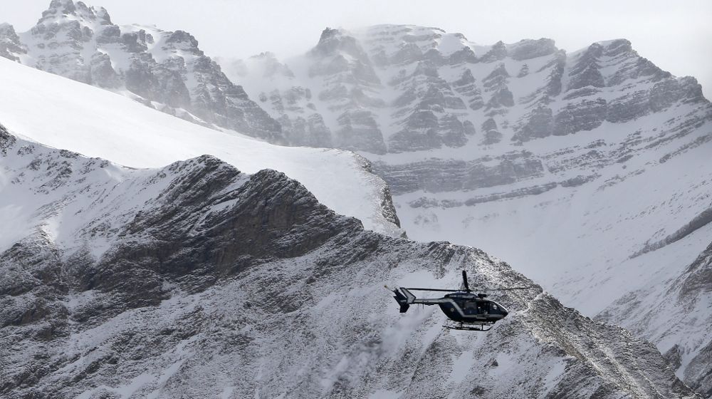 Un helicóptero de los servicios de rescate vuela sobre los restos del avión siniestrado en un área de alta montaña en los Alpes franceses.