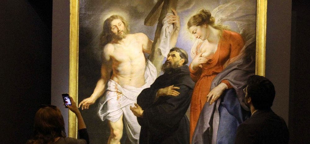 Dos personas observan el cuadro "San Agustín entre Cristo y la Virgen" en la muestra "Rubens de la Academia".