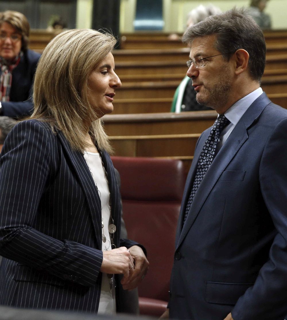 La ministra de Empleo, Fátima Báñez (i), conversa con el ministro de Justicia, Rafael Catalá, en el Congreso.