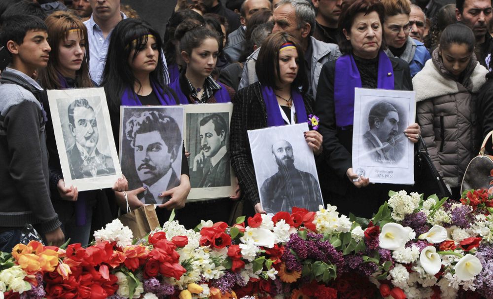 Armenios sostienen retratos de las víctimas durante una ceremonia conmemorativa por el centenario del genocidio armenio a manos del Imperio Otomano, en Yereván (Armenia), hoy, viernes.
