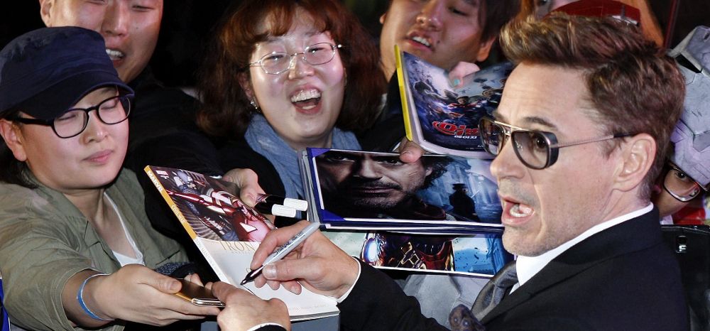 El actor estadounidense Robert Downey Jr. firma autógrafos.