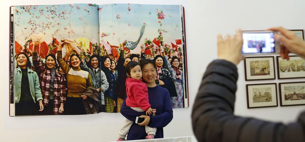 Una visitante posa con su hija junto a la obra "Shaghai" (1959) en la exposición "The Chinese Photobook".