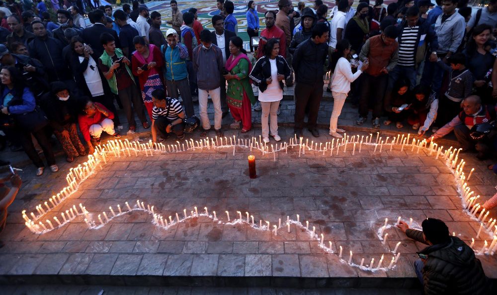 Numerosas personas participan en una vigilia en memoria de las víctimas del terremoto en Katmandú.