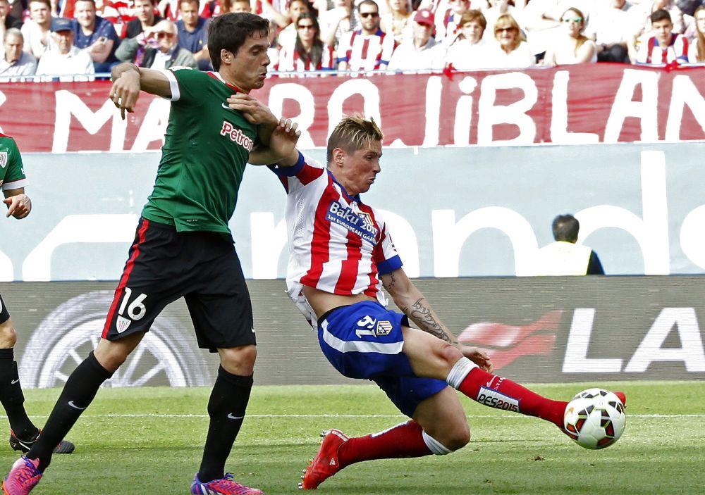 Fernando Torres (d) pelea un balón con Etxeita.