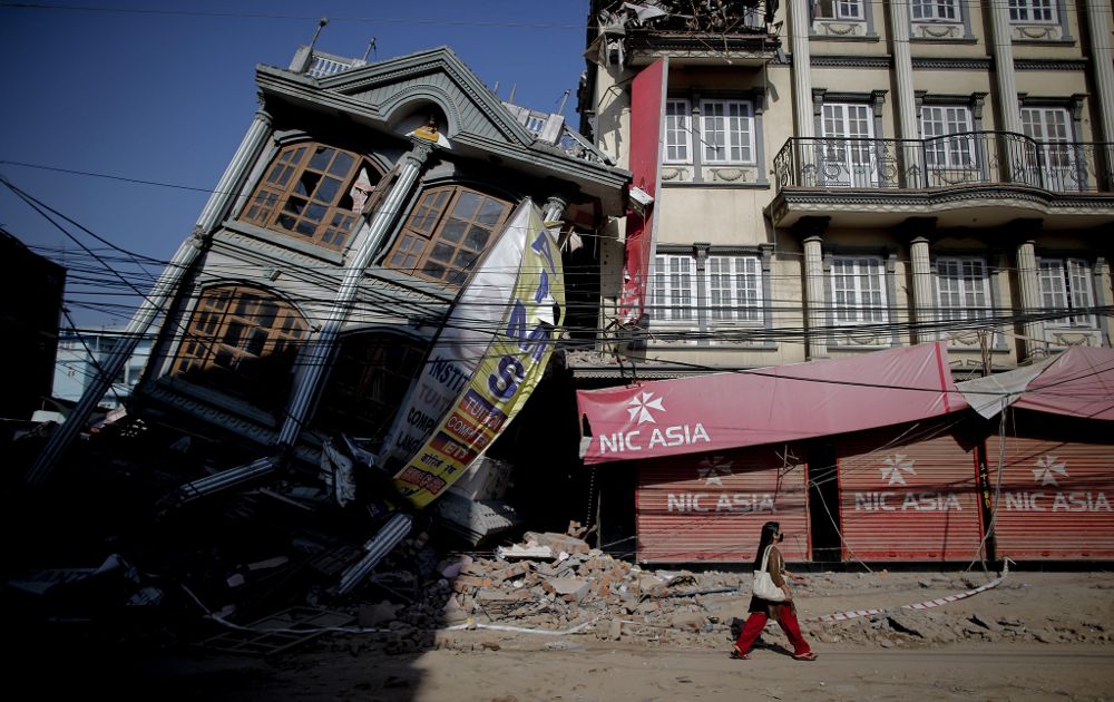 Una mujer pasea frente a un edificio destrozado tras el seísmo que desvastó Nepal el pasado 25 de abril, en Balaju, Katmandú.
