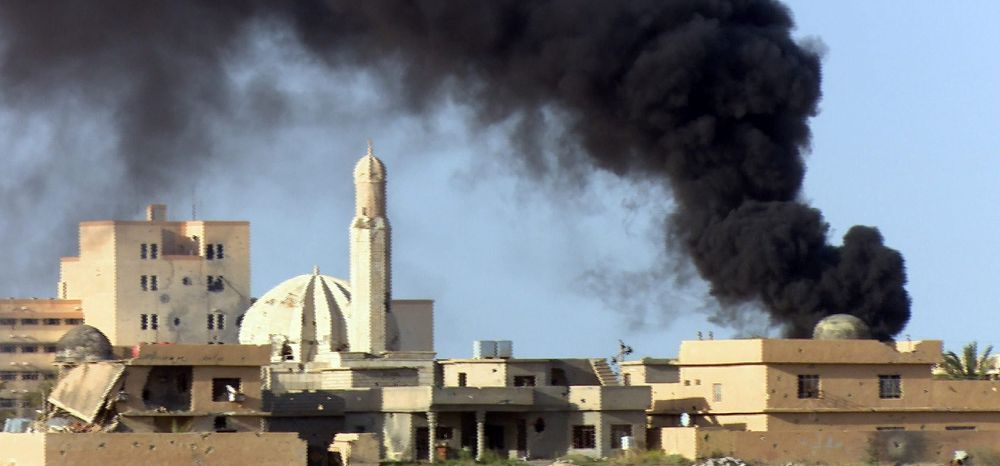 Una cortina de humo se eleva entre los edificios durante enfrentamientos entre el ejército iraquí y el grupo Estado Islámico (EI) en Tikrit, Irak.