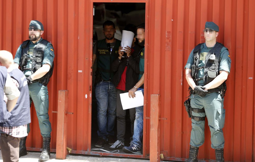 Varios agentes escoltan a uno de los detenidos en una operación contra una organización china dedicada, entre otras cosas, al blanqueo de capitales, esta tarde en el polígono Cobo Calleja en Fuenlabrada.
