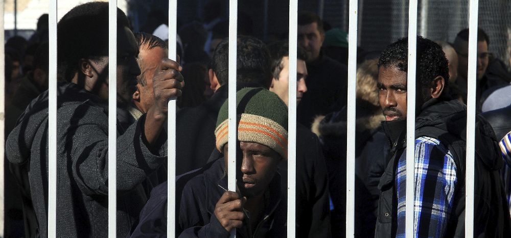 Inmigrantes forman una cola para pedir asilo político en Atenas (Grecia).