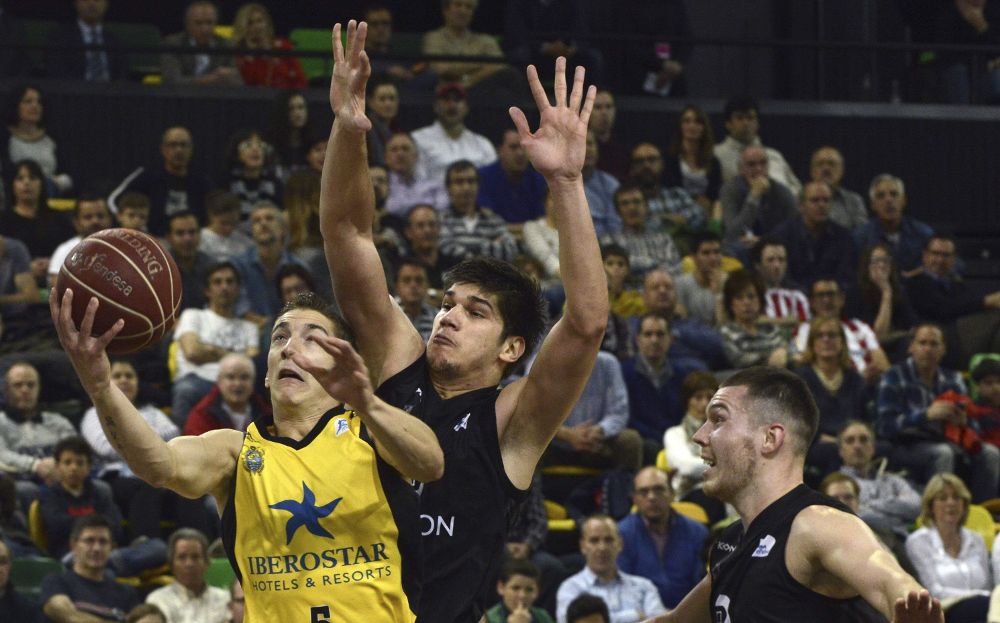 El jugador del Ibesrostar Tenerife Richotti (i) entra a canasta ante Marko Todorovic (c), de Bilbao Basket.
