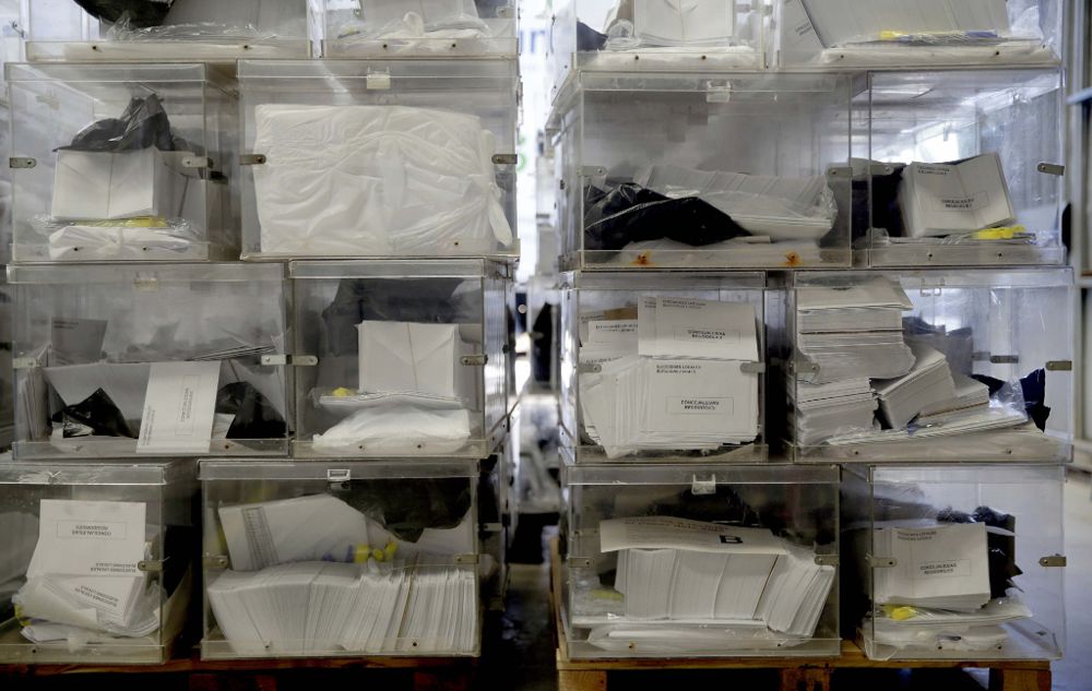 Detalle de varias urnas con el material necesario para los miembros de las mesas electorales preparadas en un almacen municipal de Barcelona.