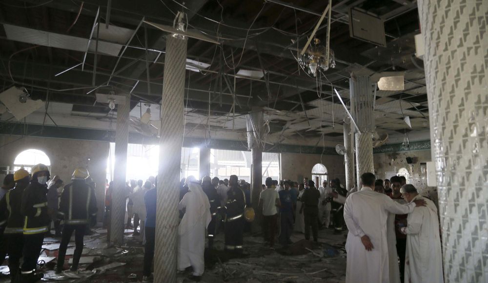 Miembros de los servicios de emergencias y varias personas observan los daños tras una explosión registrada en una mezquita de la población de Al Qadih, en la provincia saudí de mayoría chií de Al Qatif.