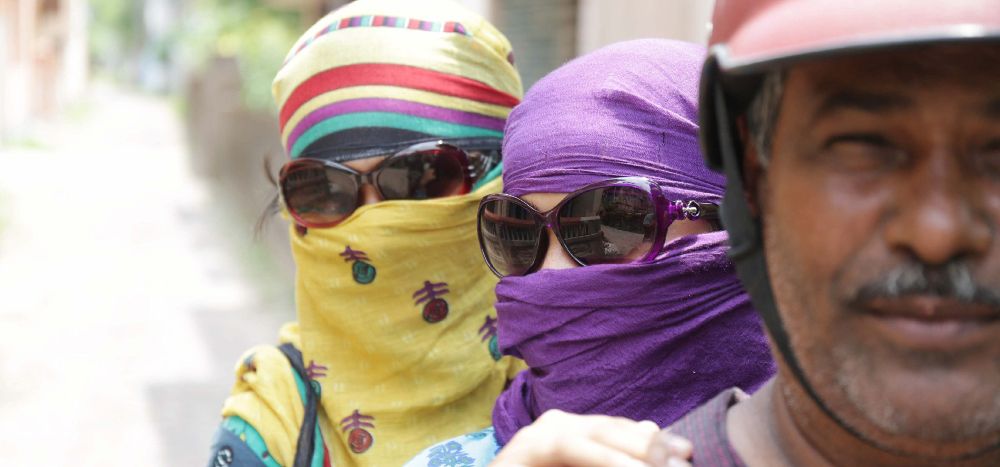 Dos mujeres indias se cubren con pañuelos para protegerse del calor.
