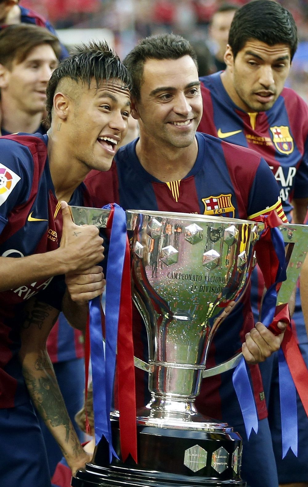 Los jugadores F. C. Barcelona, el brasileño Neymar (i) y Xavi Hernández, posan con el trofeo que les acredita como campeones del liga.