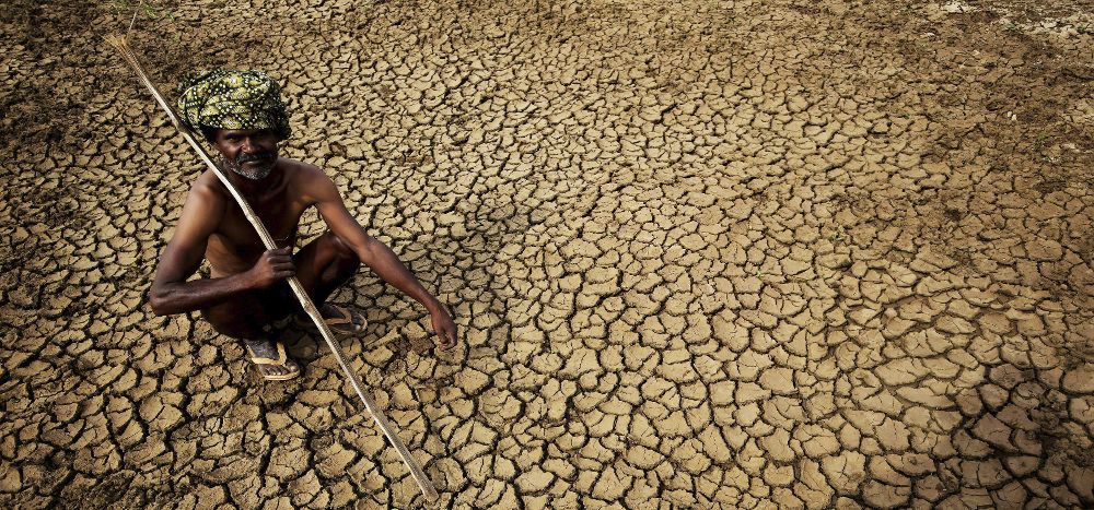 Un granjero se sienta en su tierra seca, durante una ola de calor en la localidad de Gauribidanur, en el distrito de Doddaballapur, India.