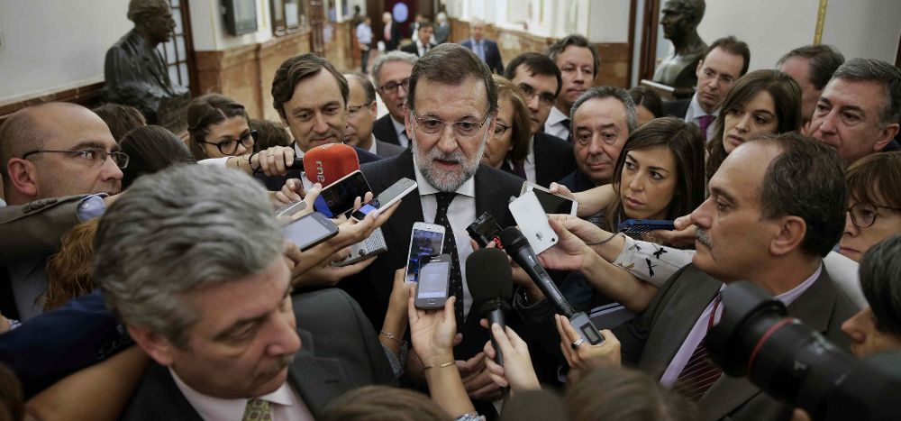 El presidente del Gobierno, Mariano Rajoy,contesta a las preguntas de los periodistas en los pasillos del Congreso de los Diputados, ayer, antes de la sesión de control al Gobierno.