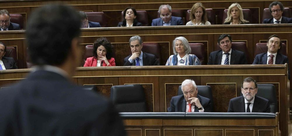 El presidente del Gobierno, Mariano Rajoy (d), acompañado por el ministro de Exteriores, José Manuel García Margallo (2d), escucha la intervención del líder del PSOE, Pedro Sánchez (i, de espaldas).