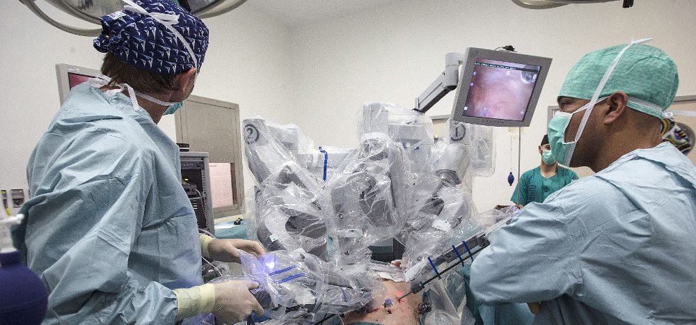 Varios médicos realizan una intervención quirurgica asistidos por el robot Da Vinci.