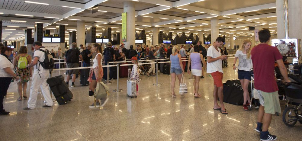 Turistas en la cola de facturación del aeropuerto de Palma de Mallorca, en una jornada de huelga de controladores aéreos.