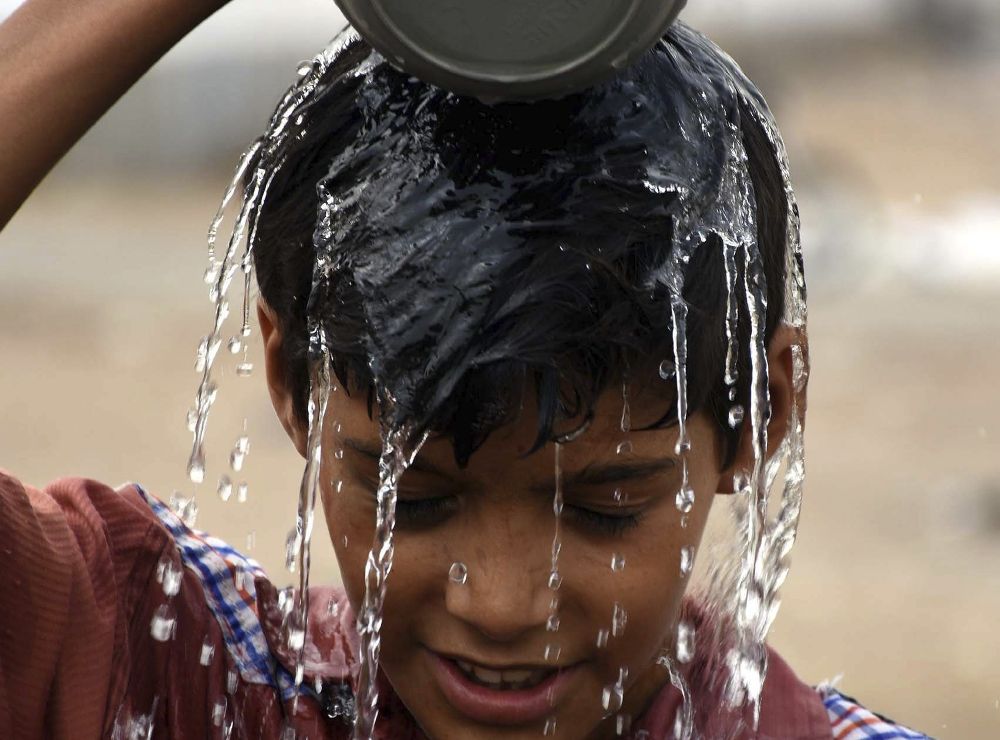 Un niño intenta refrescarse en Pakistán.