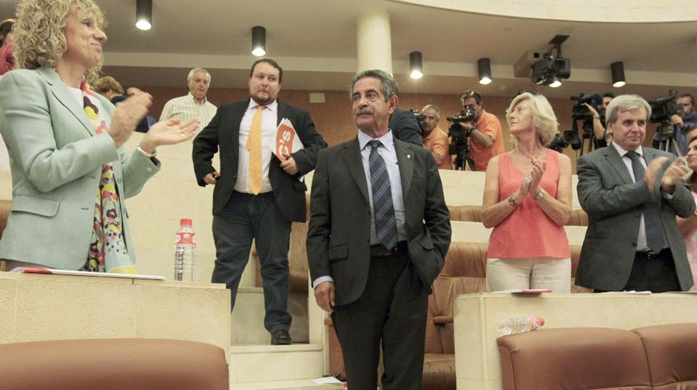 El candidato regionalista Miguel Angel Revilla es aplaudido por parlamentarios de su grupo y por la socialista, Eva Díaz Tezanos (i) con la que gobernará en coalición.