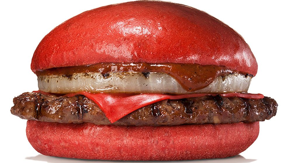 Fotografía facilitada por Burger King de la hamburguesa de queso y pan rojo, carne de res y salsa de guindilla y miso rojo que la cadena de comida rápida estadounidense lanzará de forma exclusiva en Japón desde el próximo 3 de julio hasta mediados de agosto.
