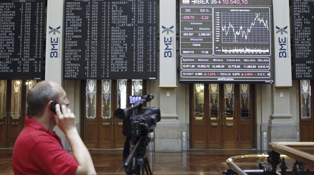 Un cámara ante un panel informativo de la bolsa de Madrid.