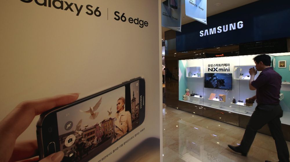 Un hombre pasa junto a un cartel publicitario de Samsung Electronics en la sede de la compañía en Seúl (Corea del Sur).