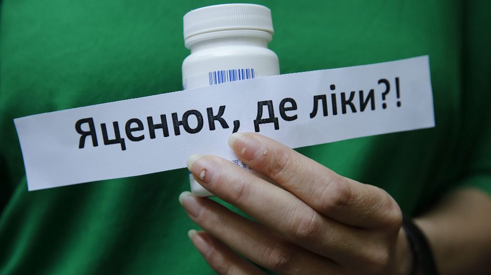 Una activista muestra un cartel que reza "Yatsenyuk ¿dónde está nuestra medicación?" durante una protesta para pedir medicamentos para el trataimento del sida en Ucrania.
