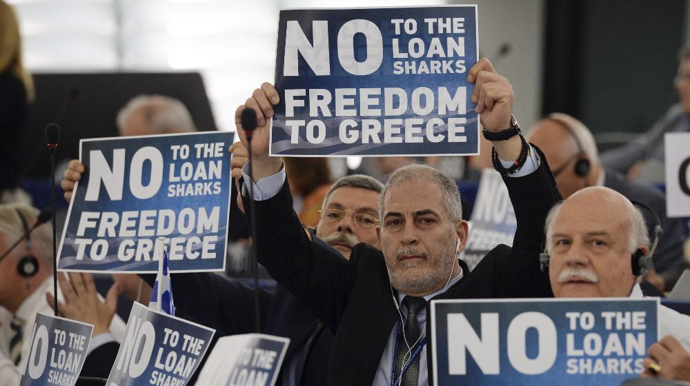 Miembros del Grupo de la Europa de la Libertad y la Democracia muestran carteles con el mensaje "No a los usureros, libertad para Grecia".
