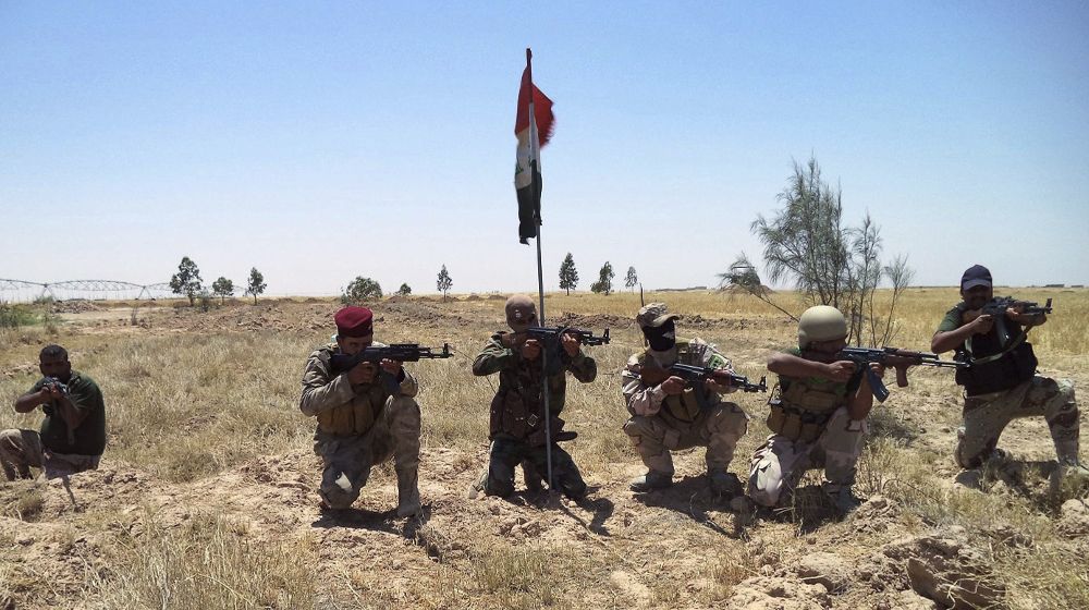 Miembros de las fuerzas de seguridad iraquíes y milicianos chiíes posan con sus armas.