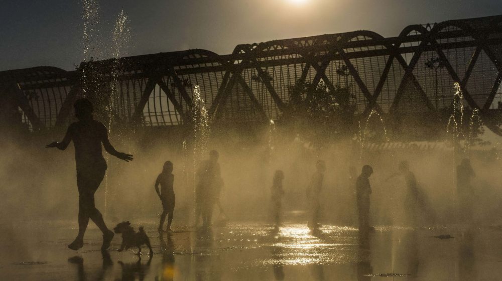 Varoas personas se refrescan en las fuentes de Madrid Río de la capital, en una jornada en la que se han registrado altas temperaturas debido a la ola de calor que azota la península.