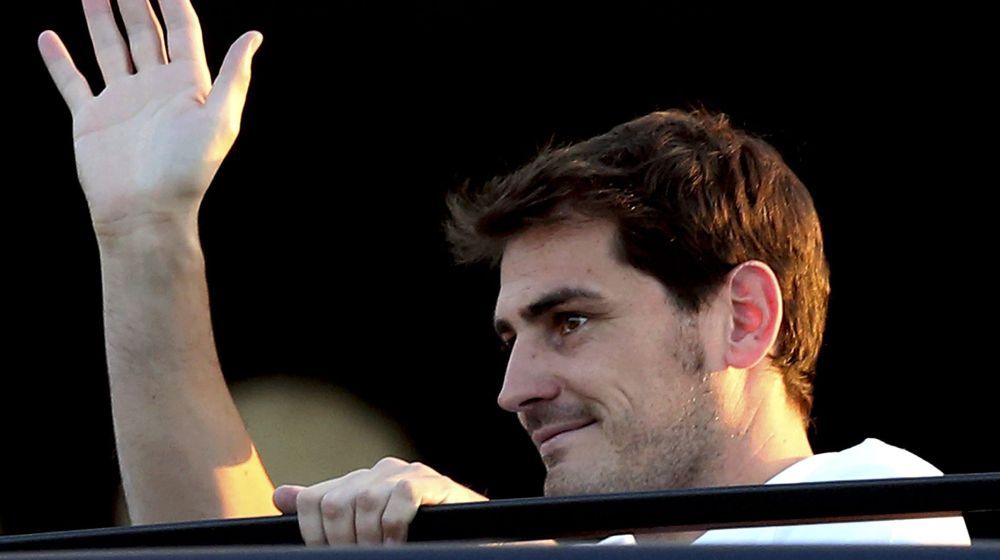 El guardameta español Iker Casillas saluda a aficionados a su llegada al aeropuerto de Sá Carneiro de Oporto, el lunes pasado.