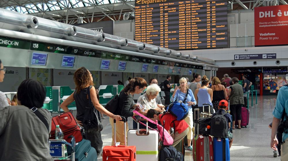 Varios viajeros hacen cola en el mostrador de la aerolínea Alitalia, que canceló el 15% de sus vuelos de corte y medio radio por la huelga de pilotos y asistentes de vuelo, en el aeropuerto de Fiumicino, Roma.
