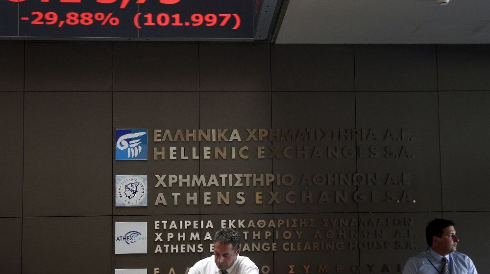 Agentes de Bolsa realizan su trabajo en el parqué de Atenas en Grecia hoy, lunes, 3 de agosto.