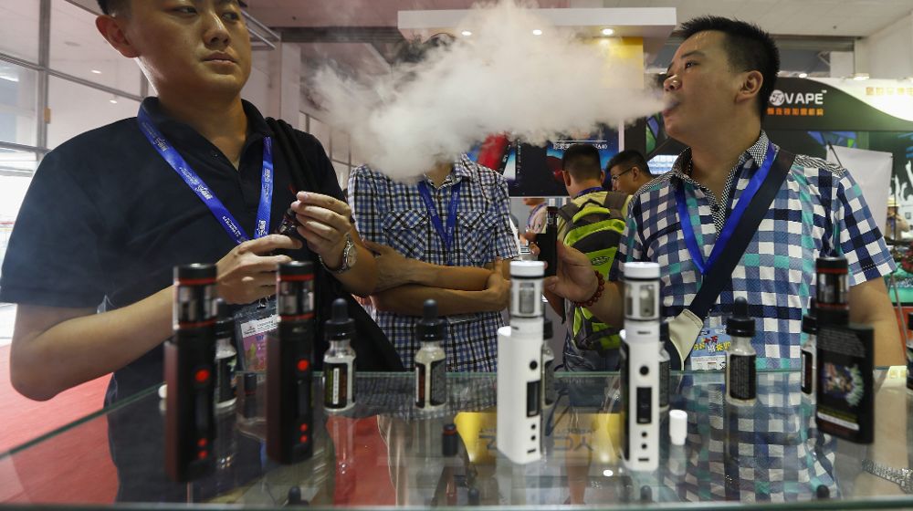 Un visitante prueba un cigarrillo electrónico en un stand de la feria "Vape China Expo" del cigarrillo electrónico y el vapor en un centro de exhibiciones de Pekín (China).