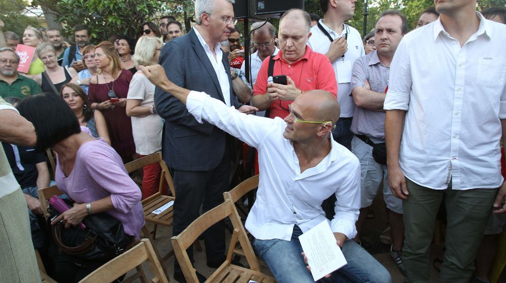 El cabeza de lista de Junts pel Sí por Barcelona, Raül Romeva (sentado), saluda a varios simpatizantes.